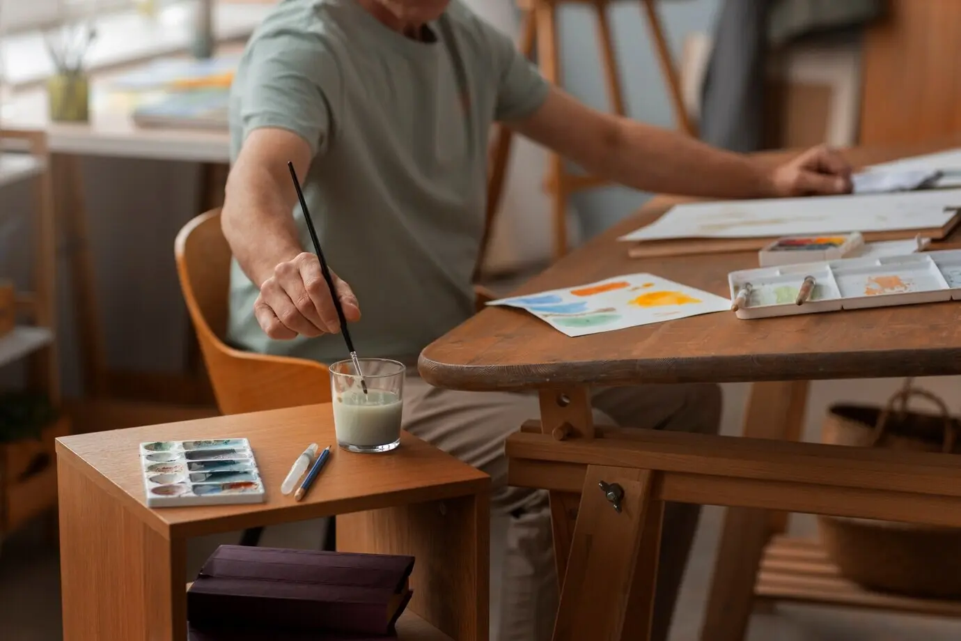 Älterer Aquarellkünstler im Atelier, der an seiner Kunst arbeitet.